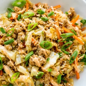 Healthy egg roll in a bowl with ground turkey, cabbage, and carrots in a skillet.